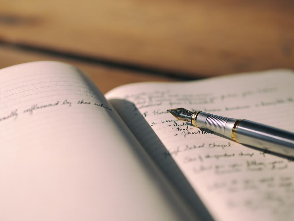 Handwritten notes in an open notebook with a fountain pen